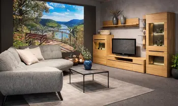 Modernes Wohnzimmer mit grauem Ecksofa, Couchtisch, Wohnwand in Holzoptik und großem Wandbild mit Flusslandschaft in stilvoller Ausstellung.